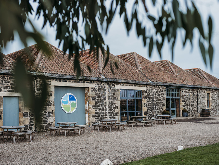 Pratis Barns exterior with round picnic tables